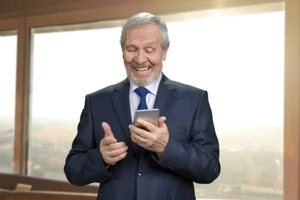 Old man in suit looking at the phone screen. — Stock Photo, Image