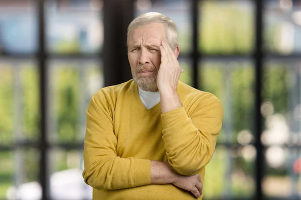 Portrait of old grandpa having headache. — Zdjęcie stockowe