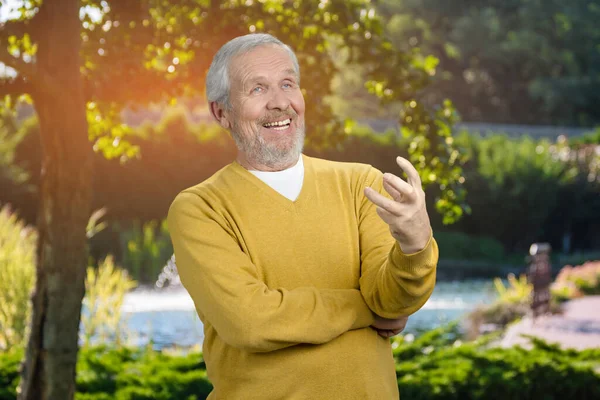 Old man talking with someone outdoor. — Stock Photo, Image