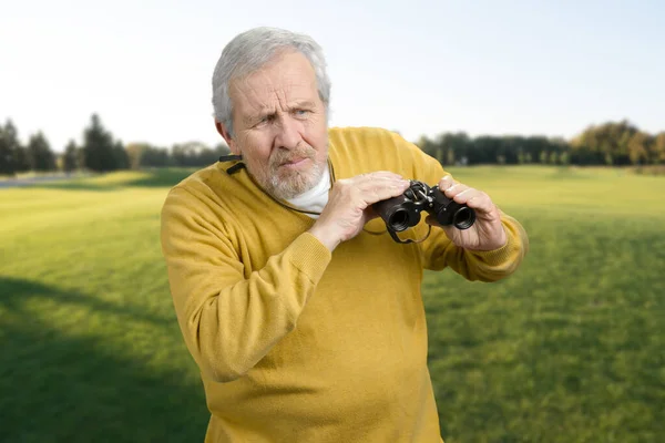 Viejo con prismáticos perplejos mirando algo . —  Fotos de Stock