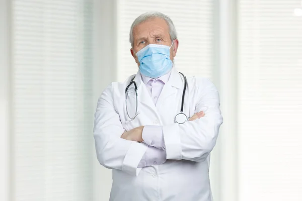 Medico serio con maschera medica e braccia incrociate . — Foto Stock