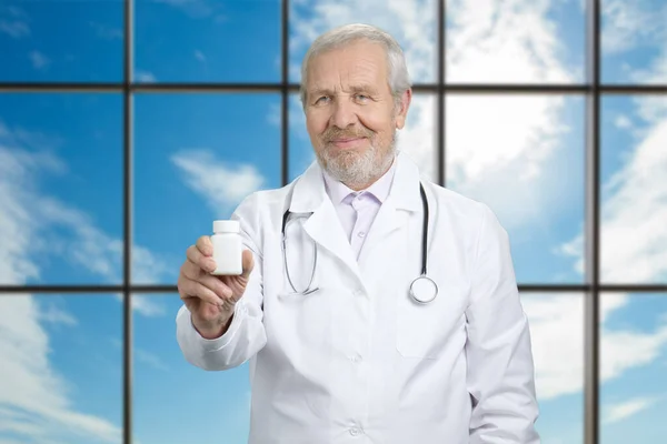 Médico segurando uma garrafa de pílulas . — Fotografia de Stock