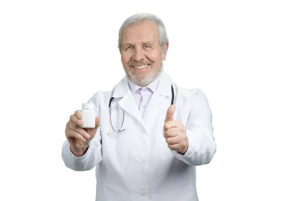 Старий лікар з банкою таблеток і великим пальцем вгору . — стокове фото