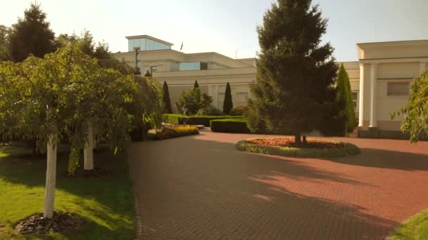 Manoir et cour avec sol pavé, arbres et buissons . — Video