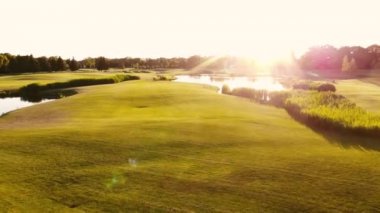 İHA 'nın yeşil çimlerin üzerinden geriye doğru uçuşu görüntüsü.