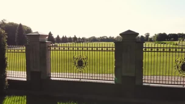 Grand terrain de golf vert derrière la clôture du parc en acier . — Video