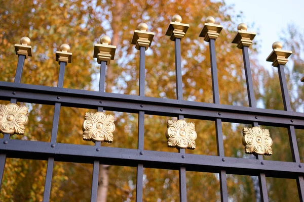 Cima di una recinzione in metallo nero con punte dorate . — Foto Stock