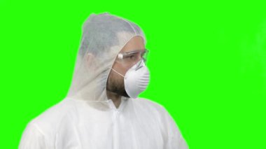 Portrait of young man wearing protective suit and looking around.