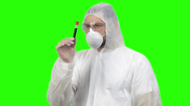 Researcher or scientist in protective clothing looking at blood test tube. — Stock video