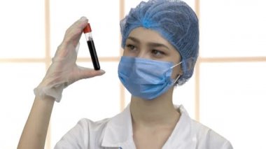 Doktor hemşire elinde kan testi tüpü kapsülü tutuyor..