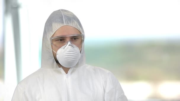 Portret van een man in witte beschermende kleding met masker en bril. — Stockvideo