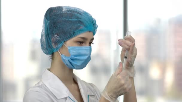 Ung kvinnlig läkare fyller en spruta med medicin. — Stockvideo