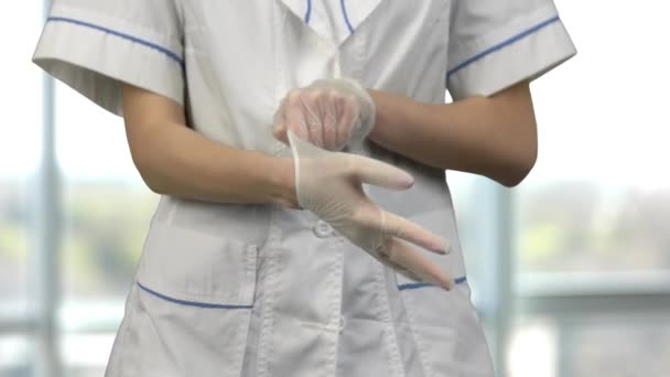 Close up vrouwelijke arts zet op rubber handschoenen. — Stockvideo