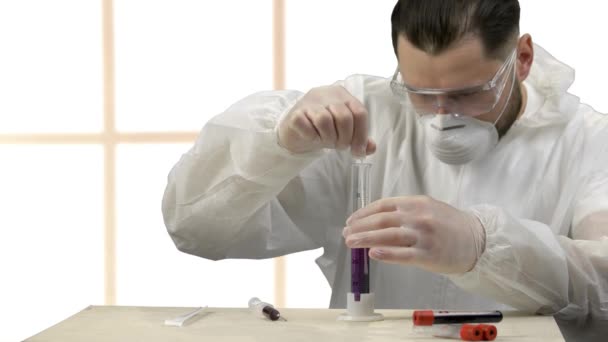 Ilmuwan medis mengaduk cairan ungu dalam tabung percobaan . — Stok Video