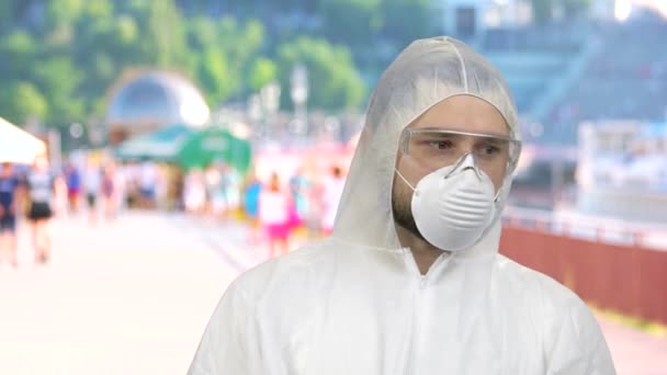 Portrait of man wearing respiratory mask and protective suit standing outdoor and looking around . — Stok Video