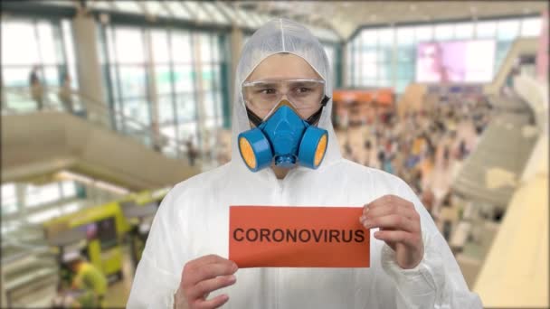 Retrato de un hombre con máscara respiratoria de pie en el aeropuerto e insta a la gente a tener cuidado coronavirus . — Vídeos de Stock