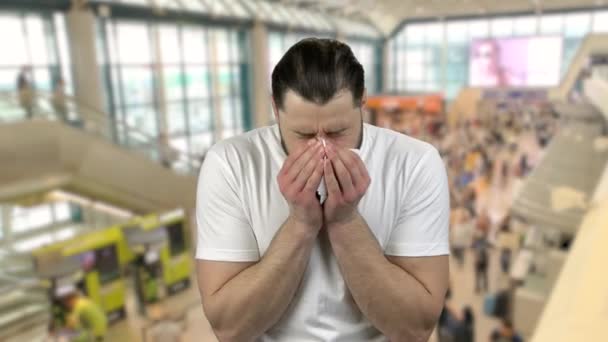 Retrato del hombre en un centro comercial o aeropuerto estornudando con sangre . — Vídeos de Stock