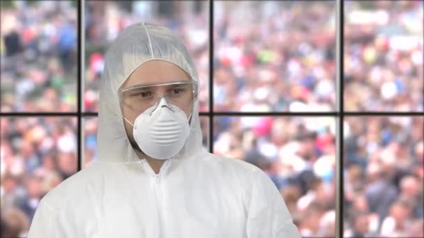Beyaz solunum maskesi ve koruyucu elbise giyen bir adamın portresi.. — Stok video