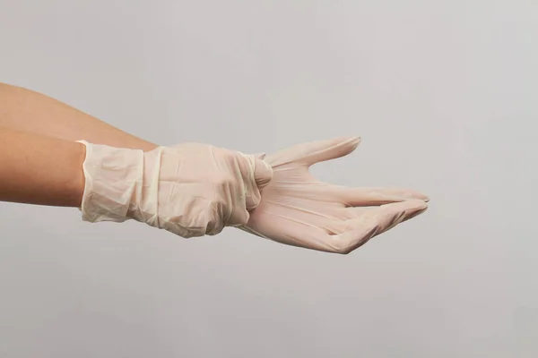 Mettre des gants blancs stériles jetables sur fond blanc . — Photo