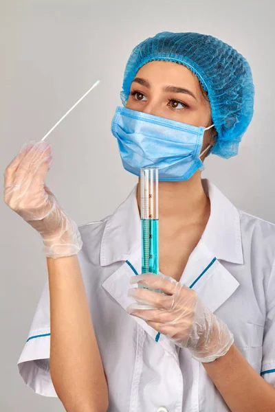 Young female doctor with swab and medical test tube. Stock Photo