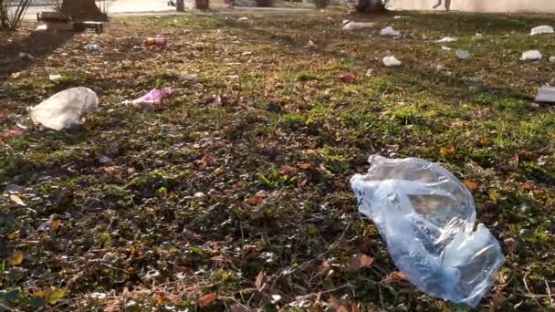 Выброшенный пластиковый мусор на траву . — стоковое видео