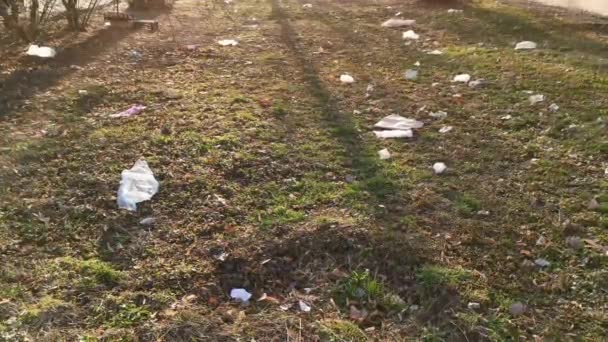 Vysypané plastové harampádí na trávě. — Stock video