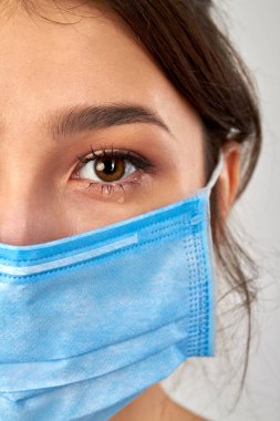 Tıbbi koruyucu maske takan kadın portresi.