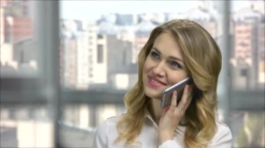 Pozitif genç iş kadını telefonda konuşuyor..