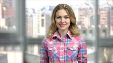 Giysiler içinde gülümseyen genç sarışın kadın portresi..