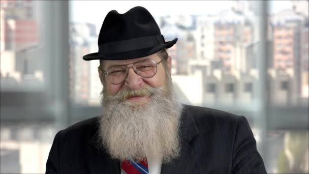 Retrato y viejo sonriente señor barbudo largo con sombrero negro y chaqueta . — Vídeos de Stock