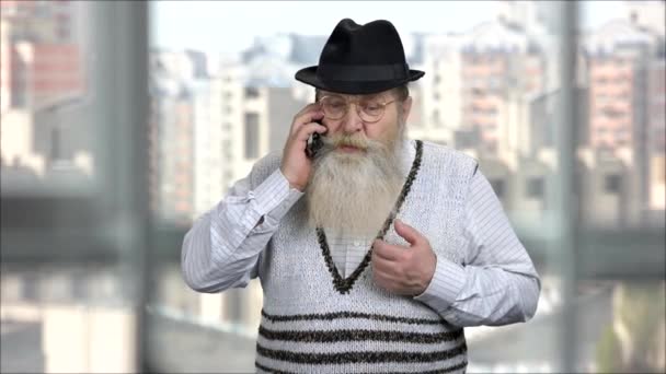 Allvarligt missnöjd senior man talar i telefon. — Stockvideo