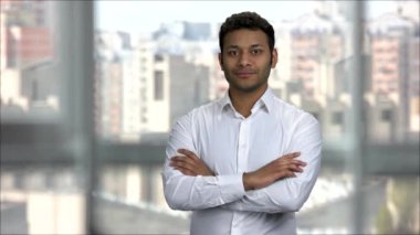 Kollarını kavuşturmuş gülümseyen Hintli adam..