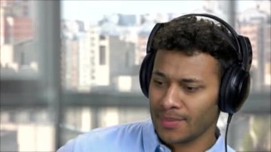 Yakın plan Arap adam kulaklıkla müzik dinliyor..