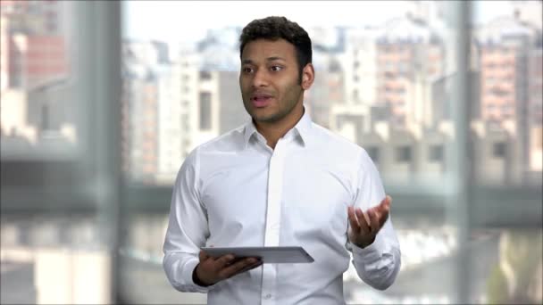 Homem indiano dando discurso de apresentação no escritório segurando tablet pc . — Vídeo de Stock