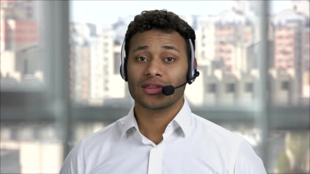 Jovem índio positivo trabalha em um call-center . — Vídeo de Stock