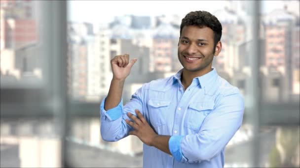 Guapo joven indio hombre señalando hacia atrás . — Vídeos de Stock