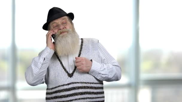 Portret van een serieuze oude gepensioneerde man aan de telefoon. — Stockvideo