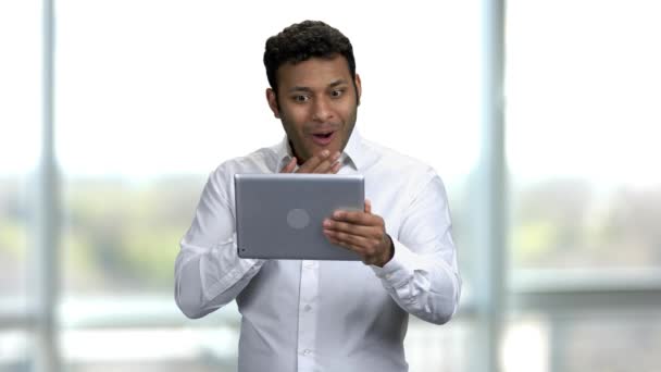 Retrato de un joven indio emocional positivo con tableta pc . — Vídeos de Stock