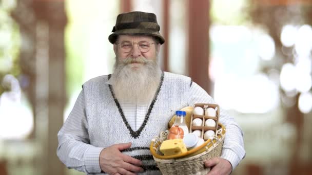 Old happy man holding straw basket of food and showing thumb up. — Stock Video