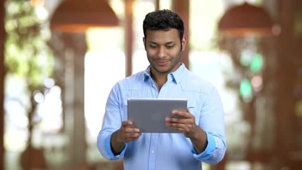 Homem de pele marrom segurando tablet pc e saudação com alguém on-line . — Vídeo de Stock