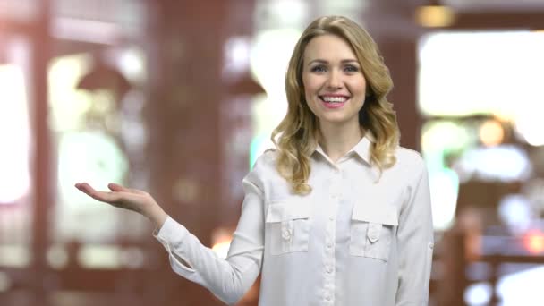 Junges blondes Mädchen zeigt Kopierraum mit der rechten Handfläche nach oben. — Stockvideo