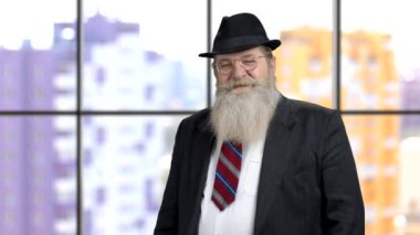 Takım elbiseli zengin yaşlı adam baş parmağını gösteriyor..