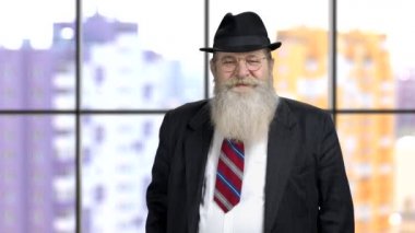 Resmi takım elbiseli yaşlı işadamı elinde hediye kutusu tutuyor..