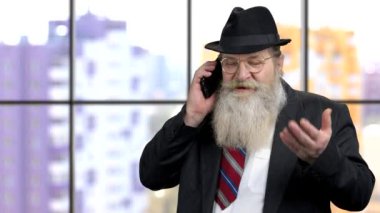 Takım elbiseli yaşlı adam telefonda iş görüşmesi yapıyor..