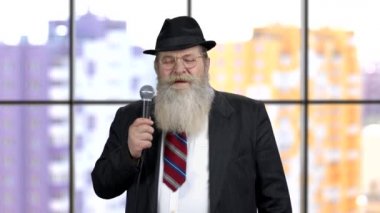 Mikrofon konuşması yapan yaşlı sakallı iş adamı..