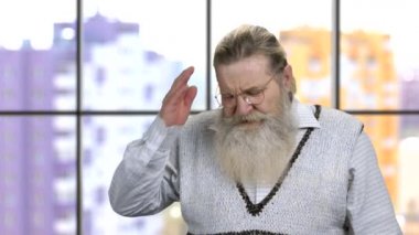 Gözlüklü yaşlı büyükbaba korkunç bir baş ağrısı çekiyor..