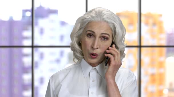 Velha senhora alegre com cabelos grisalhos falando no telefone . — Vídeo de Stock