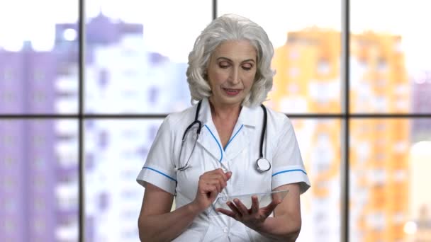 Anciana doctora usando maqueta de vidrio transparente y muestra el pulgar hacia arriba . — Vídeos de Stock