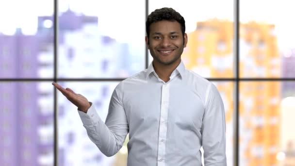 Young happy man shows empty copyspace with his both palms up. — Stock Video