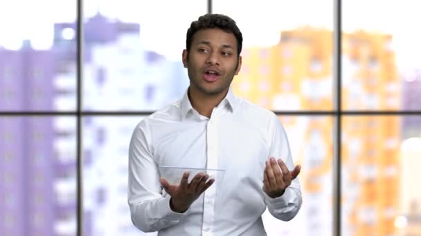 Young man giving business speech holding and swiping glass mockup tablet. — Stock Video